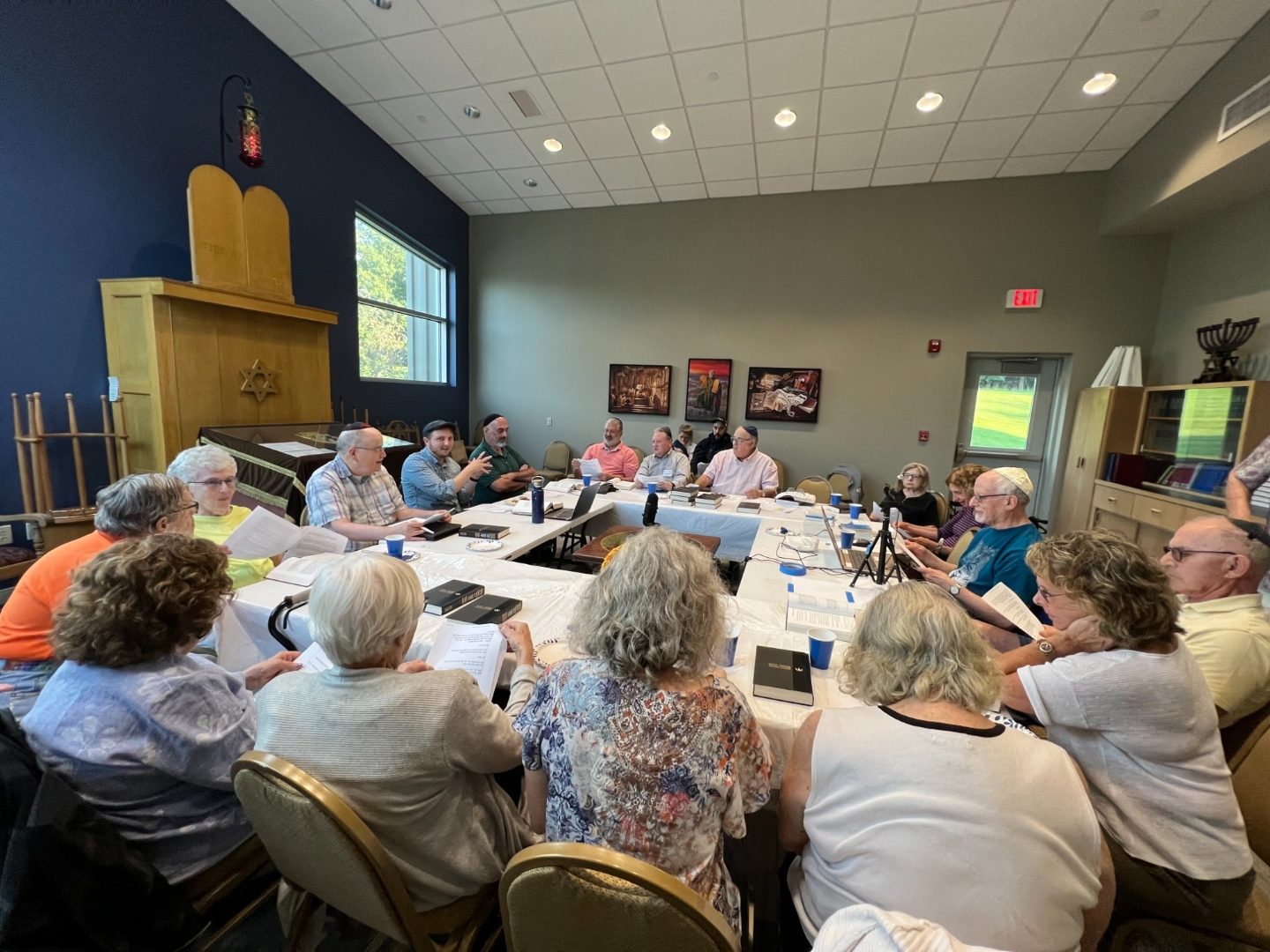 Adults studying together around tables in the Temple Israel sanctuary.